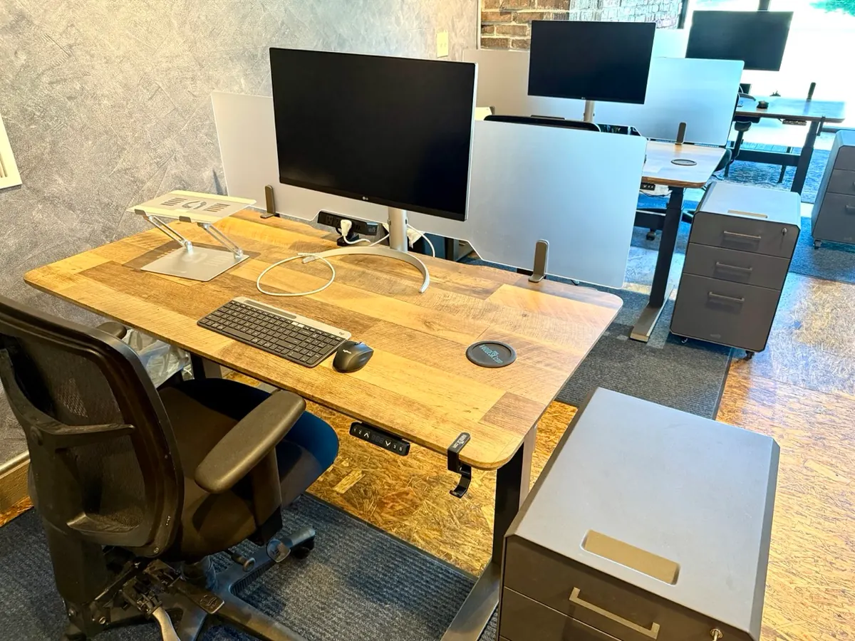 Sit/stand desk with a 27-inch 4K monitor, keyboard, and laptop stand